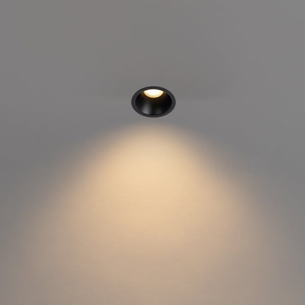 LED Einbaustrahler rund schwarz mit warmweißem Lichtkegel.