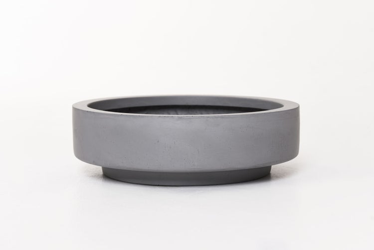 Flache graue Pflanzschale in Betonoptik mit rundem Design.