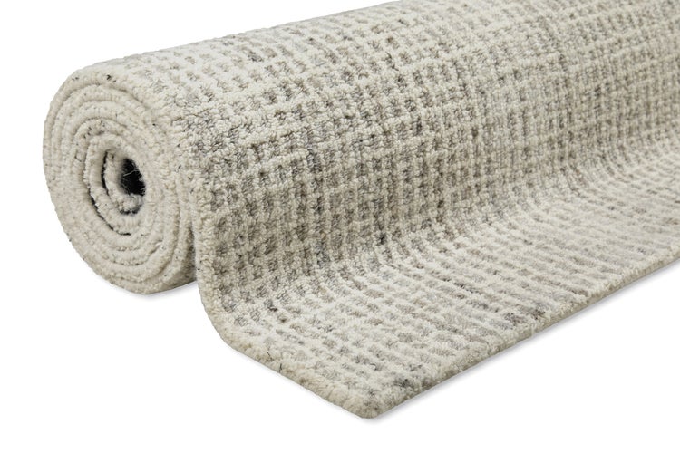 Aufgerollter Teppich mit strukturierter Oberfläche und Waffelmuster.