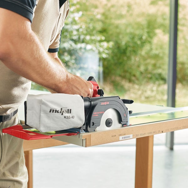 Handwerker beim Zuschneiden einer Holzplatte mit einer Mafell KSS 40 18M bl Kappsaege inklusive Fuehrungsschiene