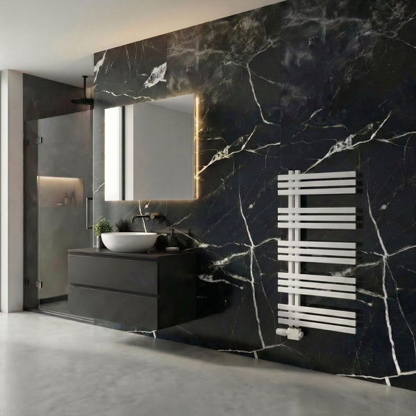 Modernes Badezimmer mit schwarzen Marmorwandfliesen, dunklem Waschtischunterschrank, weißem Aufsatzwaschbecken, Spiegel und weißem Heizkörper.