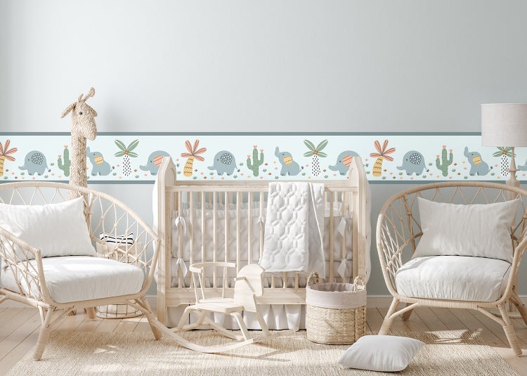 Tapetenbordüre mit Elefanten, Palmen und Kakteen in einem hellen Kinderzimmer mit Holzbett, Rattansesseln und Schaukelpferd.