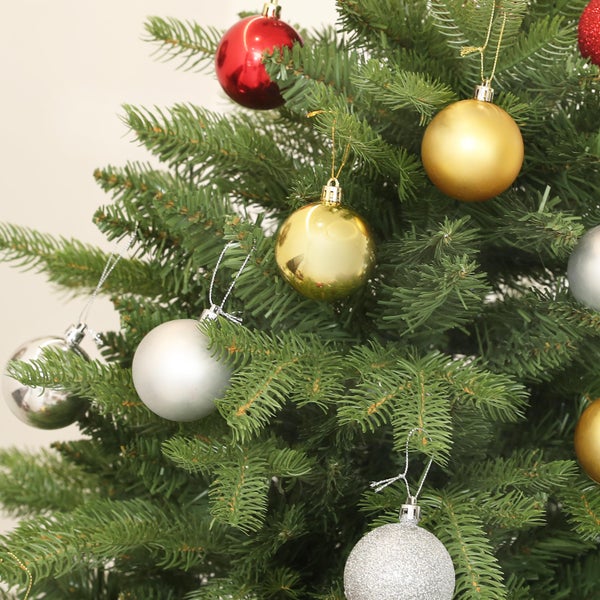 Künstlicher Weihnachtsbaum geschmückt mit Weihnachtskugeln in verschiedenen Ausführungen wie glänzend, matt und glitzernd.