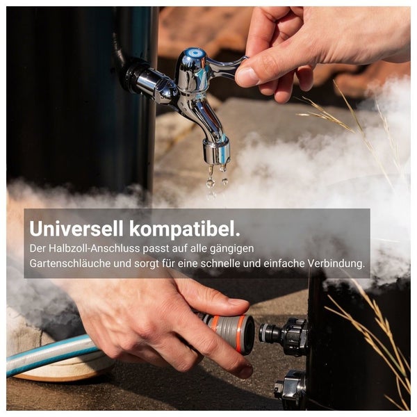 Hand bedient einen verchromten Wasserhahn an einer Regentonne, während eine zweite Hand einen Gartenschlauch anschließt.