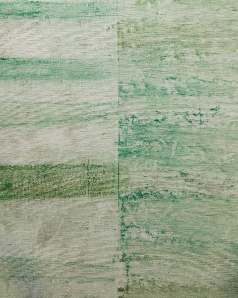 Gewebter Teppich in Grün mit abstraktem Muster im Vintage-Look, Detailaufnahme der strukturierten Oberfläche.