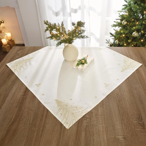 Quadratische Tischdecke mit Tannenbaum Motiv und Sternen auf Holztisch in festlichem Wohnraum mit Weihnachtsbaumdekoration.