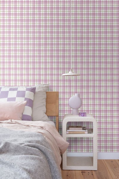 Schlafzimmer mit Bett und Nachttisch vor einer rosa karierten Tapete