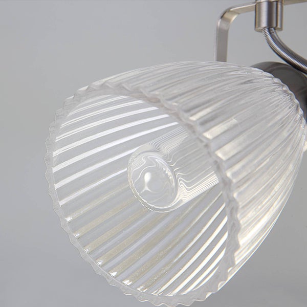 Gerippter Lampenschirm aus Glas an einer Metallhalterung für Strahler.