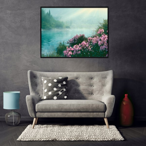 Wandbild mit einer idyllischen Bergsee Landschaft über einem gepolsterten Sofa mit Kissen und Wohnaccessoires in einem modern eingerichteten Raum.
