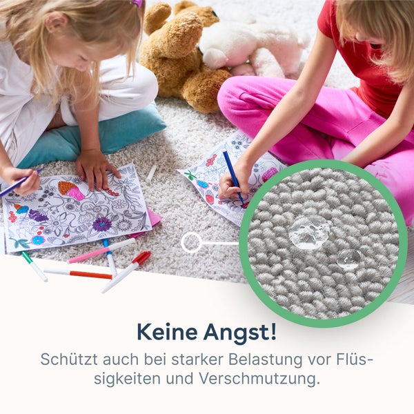Kinder malen auf einem hellen Teppich. Eine Lupenansicht zeigt Wassertropfen auf den Teppichfasern als Hinweis auf die Wasserfestigkeit.