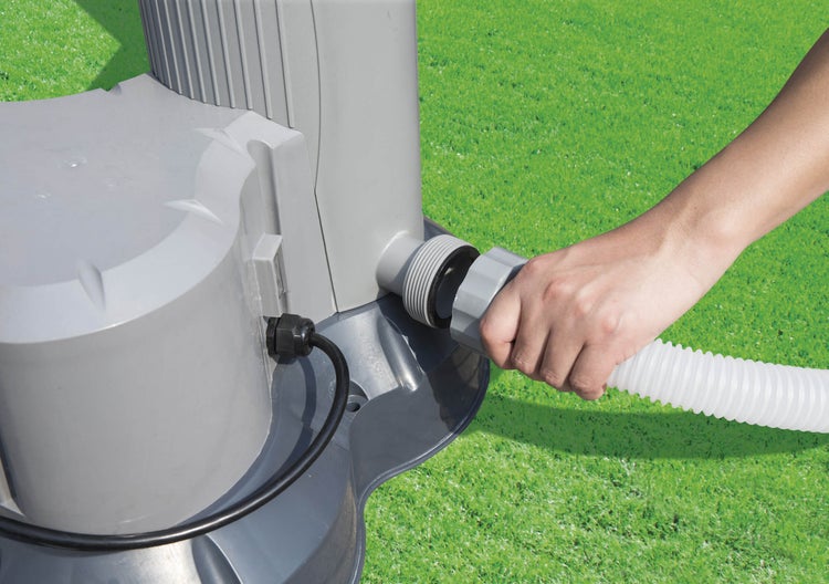 Person schließt einen Schlauch an eine Poolpumpe an.