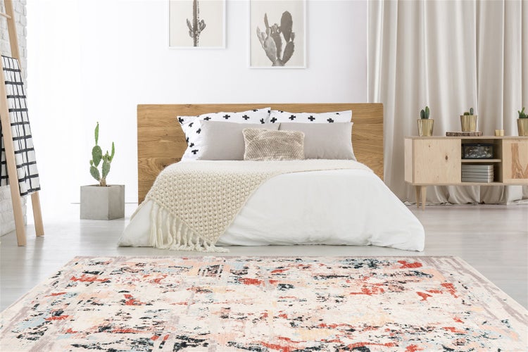 Ein moderner, rechteckiger Teppich mit abstraktem Muster im Schlafzimmer. Das Design ergänzt eine helle Einrichtung mit Holzelementen.