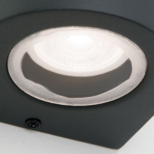 Nahaufnahme einer runden LED-Wandleuchte mit schwarzem strukturiertem Gehäuse und klarer Linse.