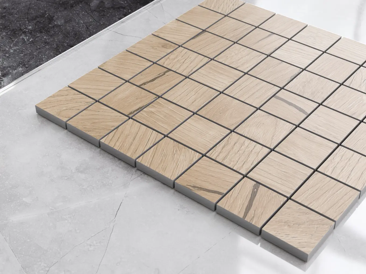 Mosaikfliese in Holzoptik aus quadratischen Steinchen, präsentiert auf einer hellen Fliese.