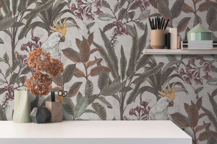 Vliestapete mit tropischem Dschungelmotiv, Kakadus und Blumen in einem modern eingerichteten Raum mit Regal und Schreibtisch.