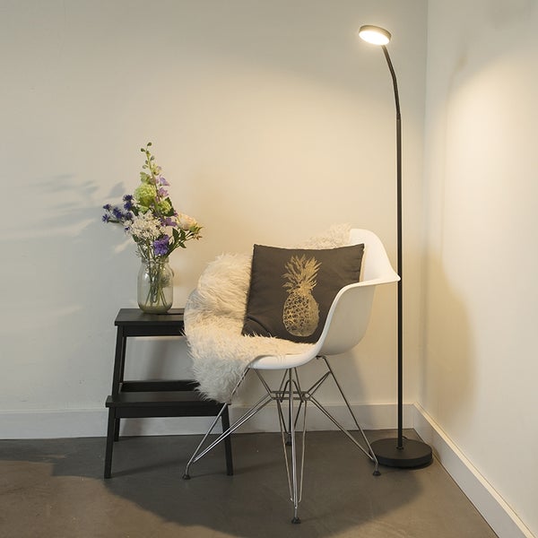 Zimmeransicht mit Stehleuchte, Stuhl, Kissen, Hocker und Blumenvase