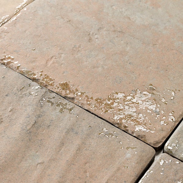 Strukturierte Terrassenplatte aus Beton mit rauer Oberfläche und feuchten Stellen