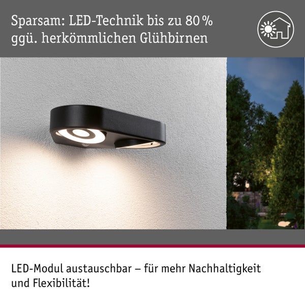 LED-Außenwandleuchte in Schwarz an einer Hauswand, beleuchtet, Hinweis auf 80 Prozent Energieersparnis und ein austauschbares LED-Modul.