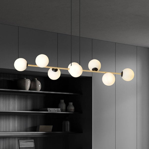 Hängelampe mit runden Lampenschirmen an einer goldenen Stange