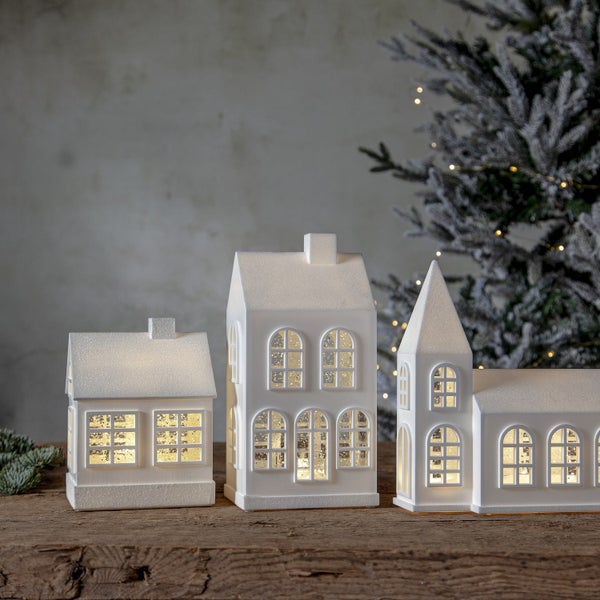 Dekorative Häuser mit Beleuchtung auf einem Holztisch