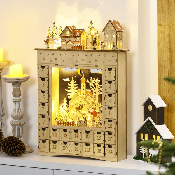 Beleuchteter Adventskalender aus Holz mit vierundzwanzig Schubladen und einer zentralen Winterszene mit Häusern, Bäumen und Figuren.