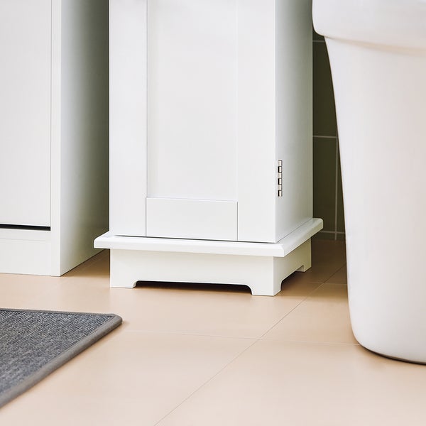 Detailansicht eines Badezimmers mit weißen Möbeln und Bodenfliesen