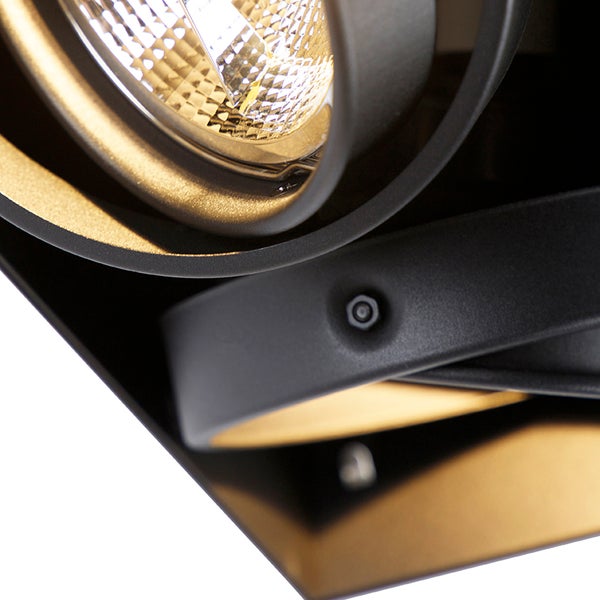 Detailaufnahme eines Metallstrahlers mit schwarzem Gehäuse, goldener Innenseite und Reflektorlampe.