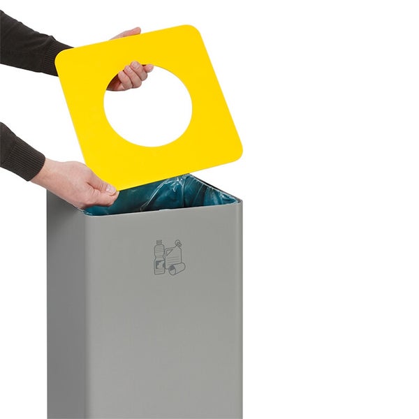 Grauer Abfallbehälter zur Mülltrennung mit gelbem Deckel mit runder Einwurföffnung und Symbolen für das Recycling von Flaschen und Dosen.