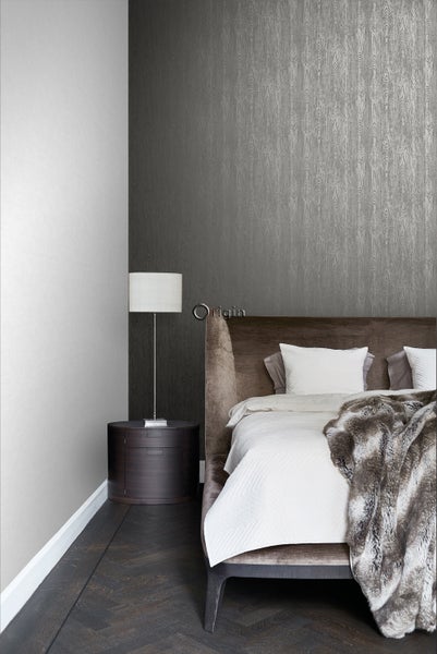 Schlafzimmer mit Bett, Nachttischlampe und Tapete mit Holzmaserung