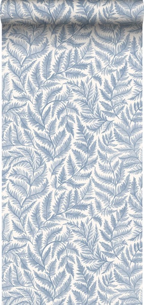 Schlafzimmer mit blau gemusterter Blättertapete, Bett, Lampe und Stuhl.