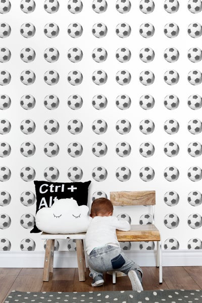 Zimmer mit Fussballtapete, Stuhl und Kind