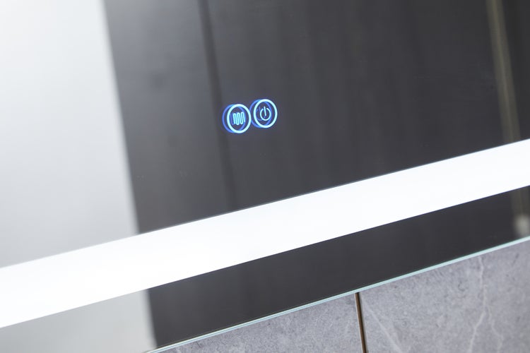 Nahaufnahme eines Spiegels mit Bedienfeldern für Licht und Heizung