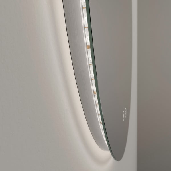 Seitenansicht eines runden Badspiegels mit LED-Hintergrundbeleuchtung und Touch-Sensor an einer weißen Wand.