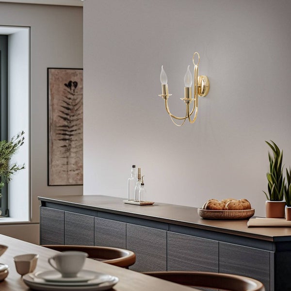Goldene Wandleuchte mit zwei Leuchten in einem hellen Küchenbereich.