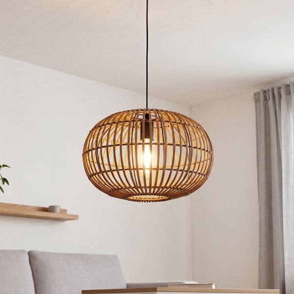 Pendelleuchte aus Bambus im Käfig-Design in einem hellen Wohnzimmer mit Sofa und Wandregal aus Holz.