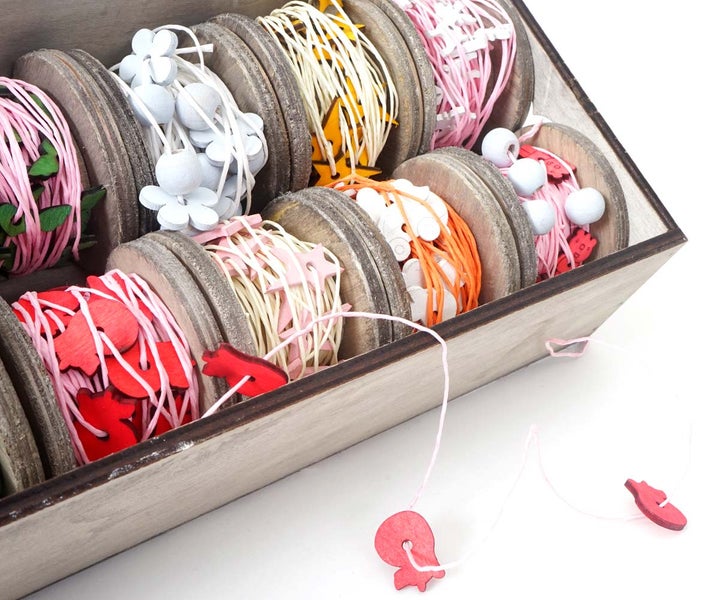 Dekoratives Band in einer Holzkiste mit Motiven wie Herzen, Sternen, Blumen und Kugeln