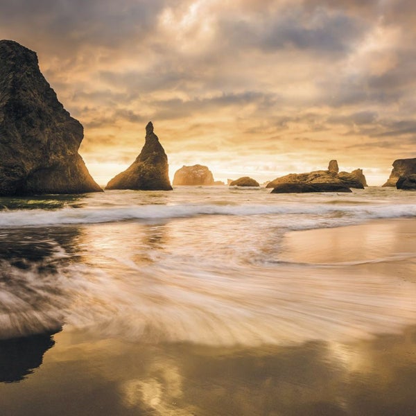 Strandlandschaft mit Felsen und Meer im goldenen Licht