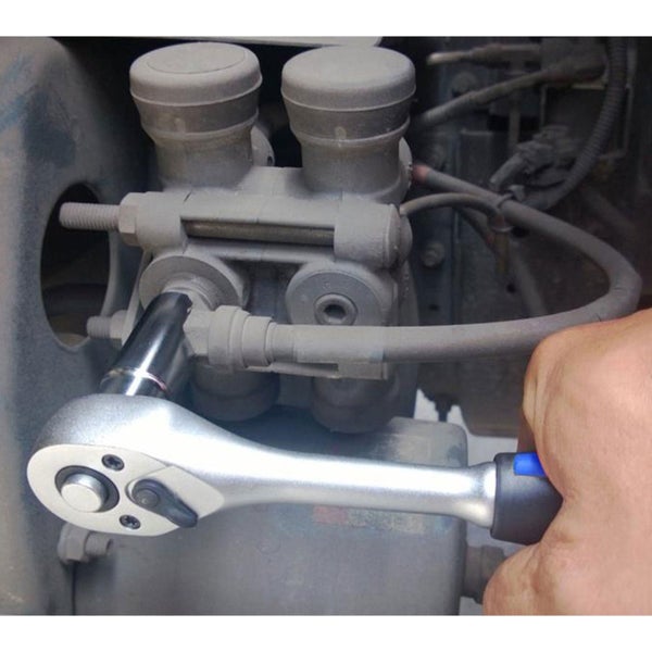 Eine Umschaltknarre mit Steckschlüsseleinsatz wird an einem mechanischen Bauteil verwendet.