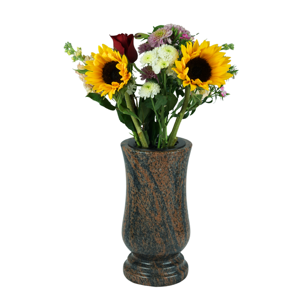 Grabvase aus Naturstein mit Blumengebinde, bestehend aus Sonnenblumen, Rosen und Chrysanthemen.