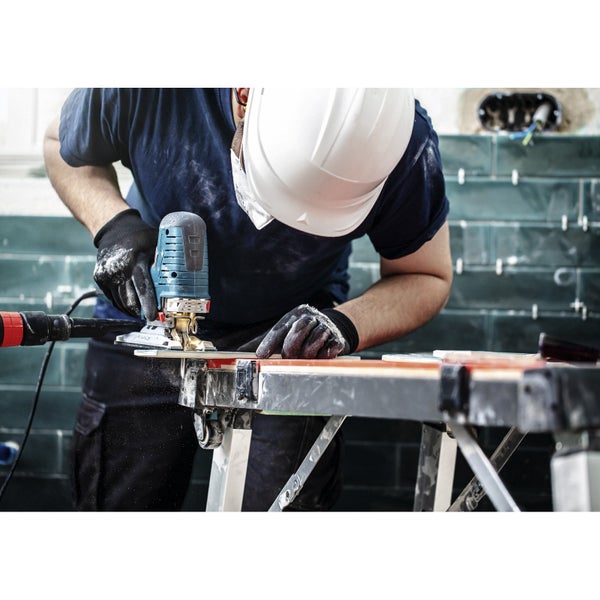 Handwerker bearbeitet Werkstück mit Stichsäge auf einer Werkbank.