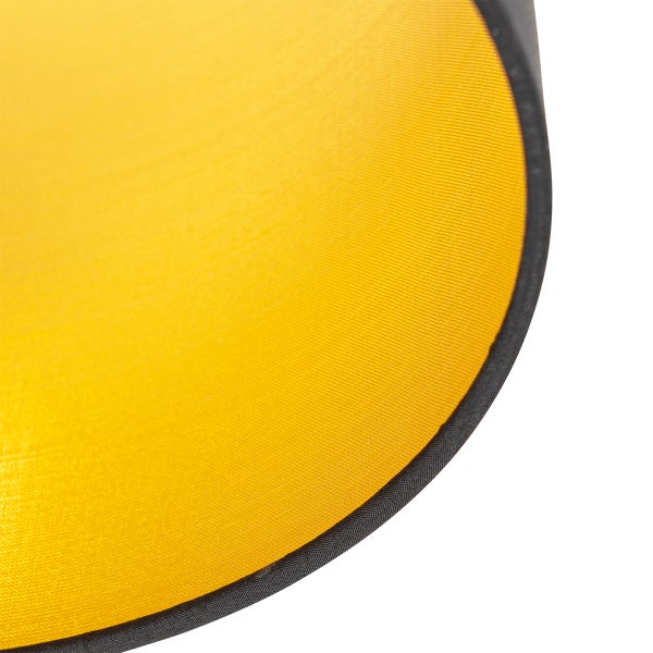 Nahaufnahme eines gelben Lampenschirms aus Stoff mit schwarzem Rand.