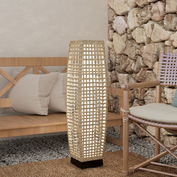Solar-Bodenleuchte in Rattan-Optik auf einer Terrasse neben einem Garten-Loungesessel.