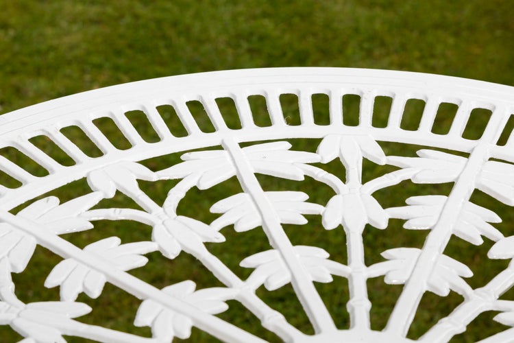 Detailansicht einer weißen Gartentischplatte mit Blattmuster