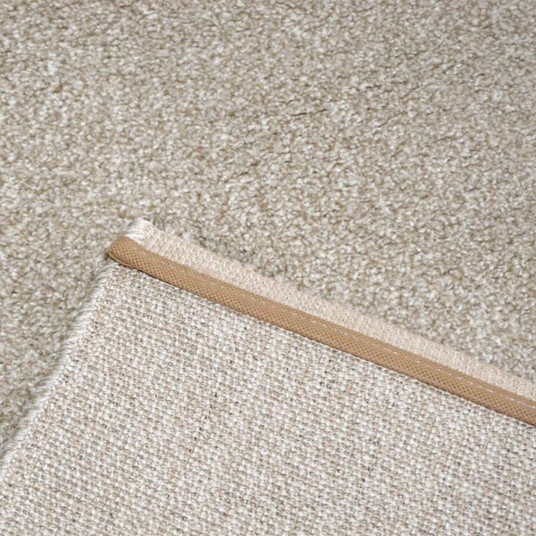 Beige farbener Teppichboden mit Detailansicht der Kettelung und der strukturierten Rückseite.