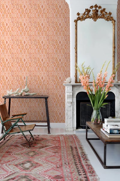 Wohnzimmer mit gemusterter Tapete, Spiegel und Dekorationen