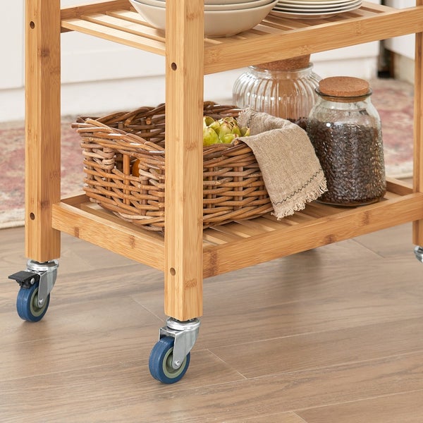 Detailaufnahme eines Servierwagens mit Rollen, Korb, Geschirr und Vorratsgläsern