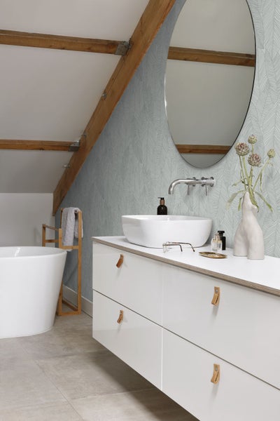 Helles Badezimmer mit Waschbecken, Spiegel und floraler Tapete