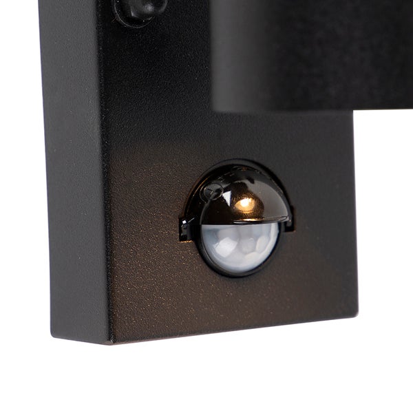 Bewegungssensor an einer schwarzen Außenwandleuchte in der Detailansicht.