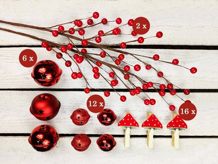 Weihnachtliches Bastelset mit Beerenzweigen, Glocken in verschiedenen Größen und Pilzklammern zur Dekoration.