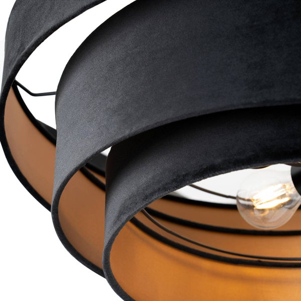 Nahaufnahme einer modernen Hängeleuchte mit schwarzem Samtschirm, goldener Innenseite und sichtbarem Leuchtmittel.